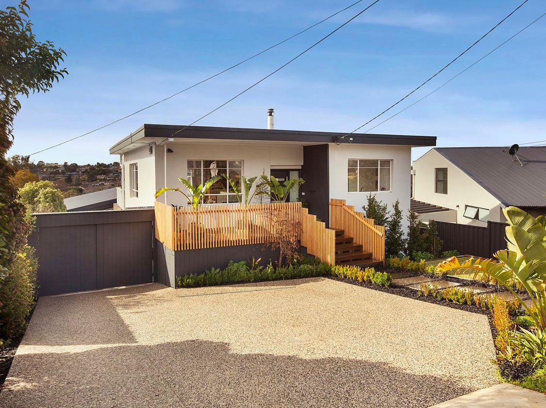 Custom home with rendered facade and timber screening by Blake Ballard Building